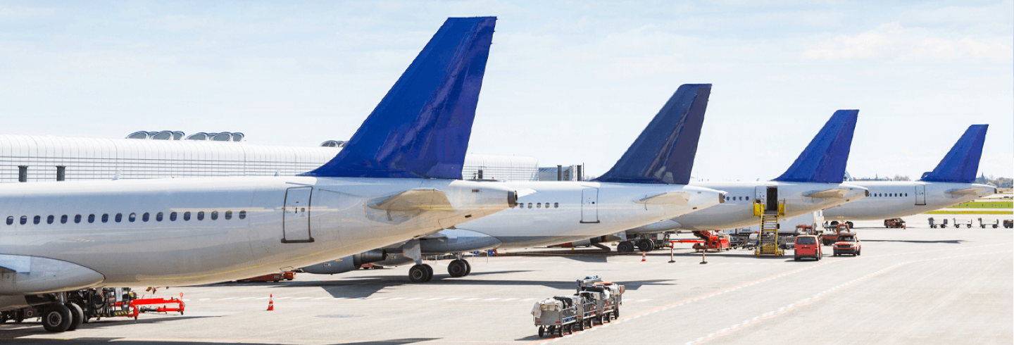 Multiple airplanes parked in their designated gates.