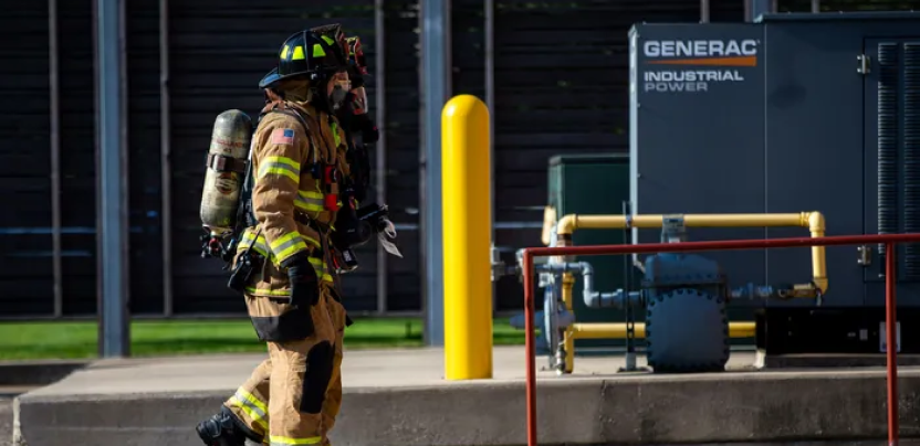 Image of a firefighter walking by a Generac generator.