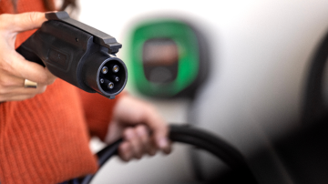  Person holding EV charger plug before plugging it in