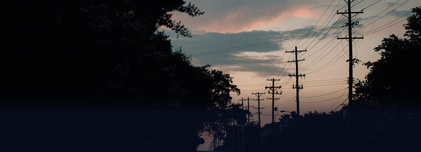 Silhouette of power lines and trees after a storm with clouds in the sky