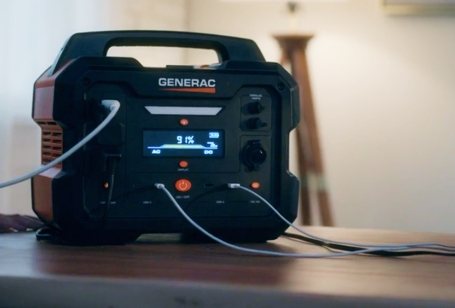 Generac portable power station with cords plugged in sitting on a table