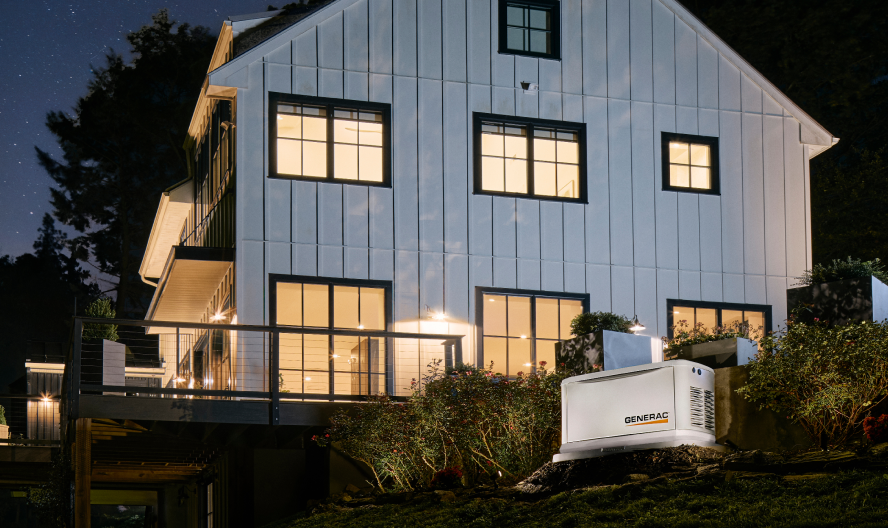 Generac generator in front of home with lights on