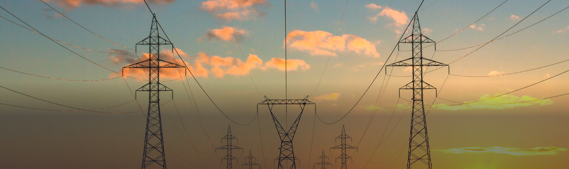 Utility power lines against setting sun sky